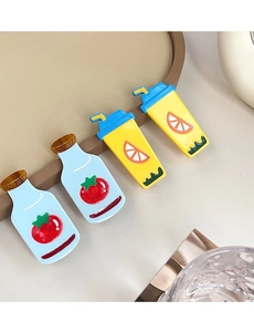 Detailed view of cute cartoon ketchup and orange juice acrylic hair clips with glossy finish