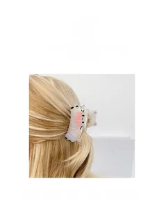 Détail d'une pince à cheveux en acétate en forme de chat avec nœud rose nacré