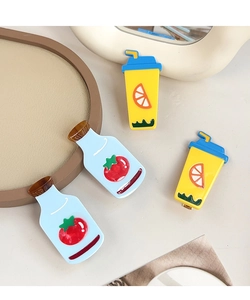 Detail view of cute resin tomato milk and lemon tea hair clips on a decorative tray