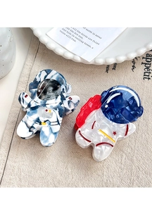 Detail of cute astronaut hair claw clips with marble texture on vintage background