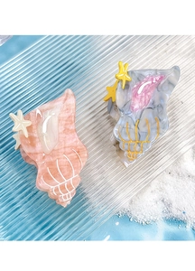 Detailed close-up of shell-shaped acetate hair claws with starfish accents on sand