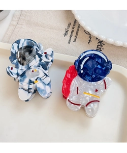 Detail of cute astronaut claw clips with marble texture and colorful acetate finish