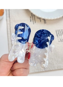 Detail of large acetate butterfly hair claw clip with blue marble pattern held by hand