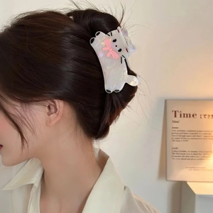 Pince à cheveux chat blanc en acétate avec nœud rose portée par un mannequin