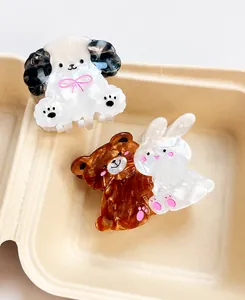 Close-up of acetate animal hair claws showing marble texture and cute puppy bear designs