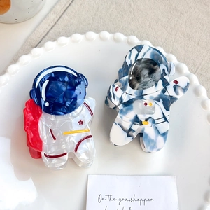 Cute astronaut acetate hair claws in white and marble blue on a ceramic tray