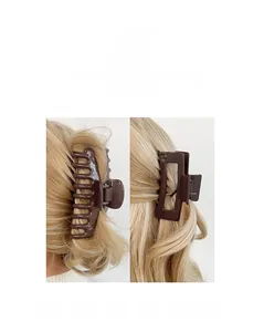Detailaufnahme dunkelbrauner Haarklammern auf blondem Haar für elegante Hochsteckfrisuren