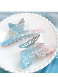 Detailed close-up of blue and pink gradient acetate fish tail and butterfly hair claws