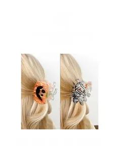 Gros plan de pinces à cheveux Halloween citrouille et fantôme sur cheveux blonds