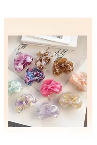 Flat lay of colorful bow-shaped hair claw clips with marble and gradient textures