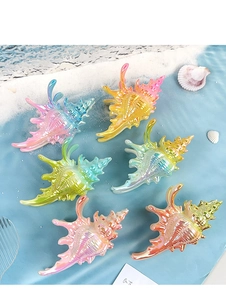 Détail de pinces à cheveux en forme de coquillage coloré avec fini nacré irisant
