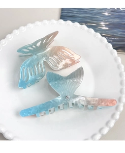 Detail of gradient acetate butterfly and fishtail hair claws with pearlescent finish