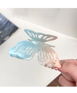 Detail of a large butterfly hair claw clip with blue and pink gradient pearlescent texture