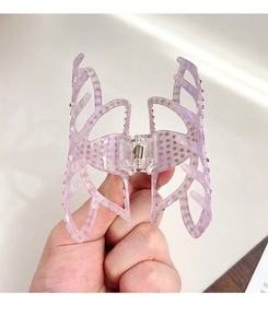 Détail de la pince à cheveux papillon marbrée violette avec des strass étincelants