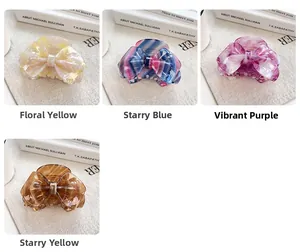 Detailed close-up of bow-shaped hair claws in four floral and marble acetate patterns