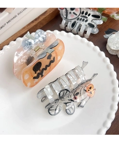 Détail des pinces à cheveux Halloween avec citrouille et fantôme en fibre d'acétate