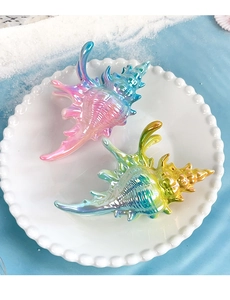 Vue macro de pinces à cheveux conque colorées avec éclat nacré sur une assiette blanche