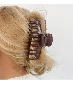 Detailansicht der großen braunen Haarklammer mit starkem Halt für langes blondes Haar