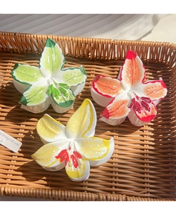 Détails des pinces à cheveux en forme de lys colorés en vert, rose et jaune sur plateau