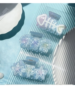 Detailed view of ocean-themed hair clips in shell, starfish, and fish bone shapes