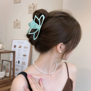 Pince à cheveux papillon bleue élégante avec strass portée par un mannequin pour chignon