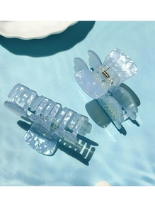 Detail of light blue translucent hair clips with jellyfish patterns on a wave background