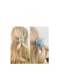 Detailed close-up of blue dolphin hair claw clip with marble texture on blonde wavy hair