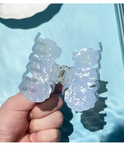 Close-up of translucent light blue butterfly hair claw clip with shell luster finish