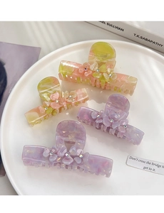 Close-up of acetic acid hair claw with 3D floral details and sparkling rhinestones