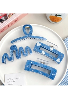Set aus vier blauen Haarklammern in Denim-Optik mit weißen Herz- und Sternmustern im Tablett