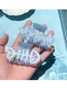 Detail of starfish and fishbone hair claws in pearlescent blue acetate material