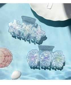 Detail shot of ocean series starfish and shell hair claws in iridescent gradient blue