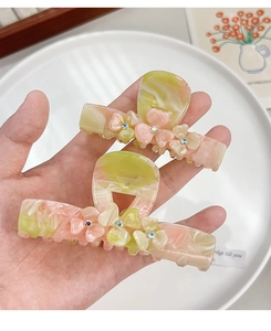 Detail of elegant acetate hair claw clip with floral patterns and sparkling rhinestones
