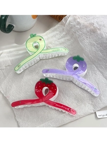 Trois pinces à cheveux aux fruits colorés avec motifs avocat et fraise sur papier