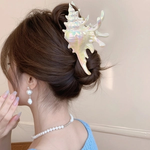 Pince à cheveux nacrée en forme de coquillage pour coiffures d'été élégantes sur modèle