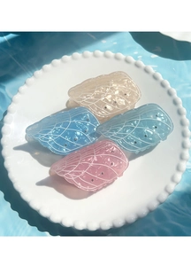 Detail of four multi-colored acetate hair claws with wing textures and rhinestones