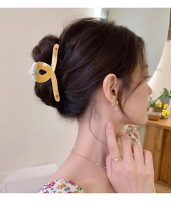Détail d'une pince à cheveux motif orange portée élégamment par une femme
