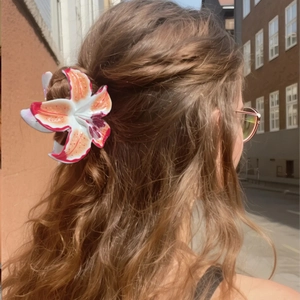 Pince à cheveux fleur de lys réaliste avec un dégradé de couleurs orange et jaune