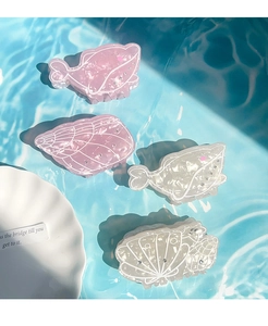 Detail of whale and seashell hair claws made of marble acetate with rhinestones