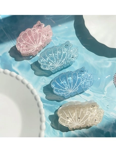 Detailed view of summer ocean shell hair claws in pink, blue, and white with starfish motifs