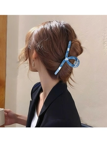 Detailansicht einer großen blauen Haarklammer mit Lucky und Nice Aufdruck im Haar