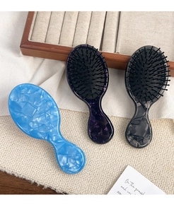 Detailed macro view of portable acetate hair combs with marble patterns and massage tips
