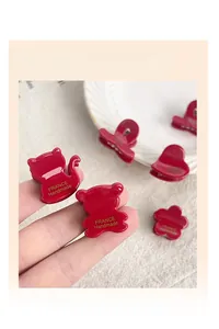 Detailed macro of red acetate hair clips with golden France Handmade lettering and heart motifs