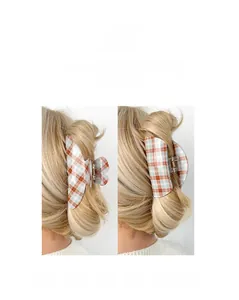 Détail d'une grande pince à cheveux à carreaux rouge et bleu sur cheveux blonds