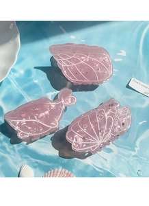 Detailed macro view of pink translucent resin ocean whale and seashell hair claw clips