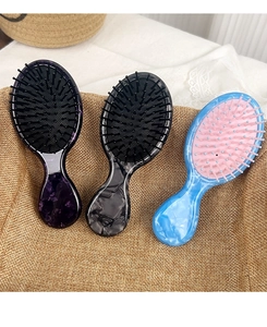 Three acetate marble pattern air cushion massage hairbrushes in a woven basket