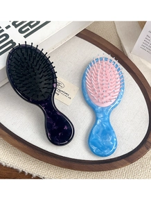 Macro view of portable mini massage hairbrushes with stylish purple and blue marble patterns