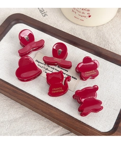 Macro shot of 6-piece dark red floral hair claw clips with gold handmade lettering