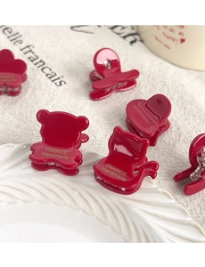 Detail of red acetate hair clips with gold France Handmade lettering and floral shapes