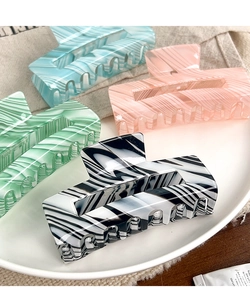 Detail view of large rectangular marble textured hair claws in pastel candy colors set